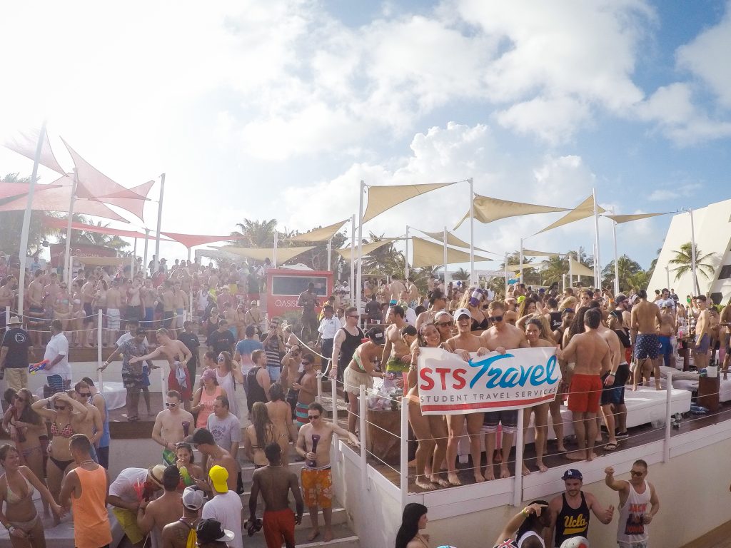 Oasis Cancun Lite holding an STS Travel Banner